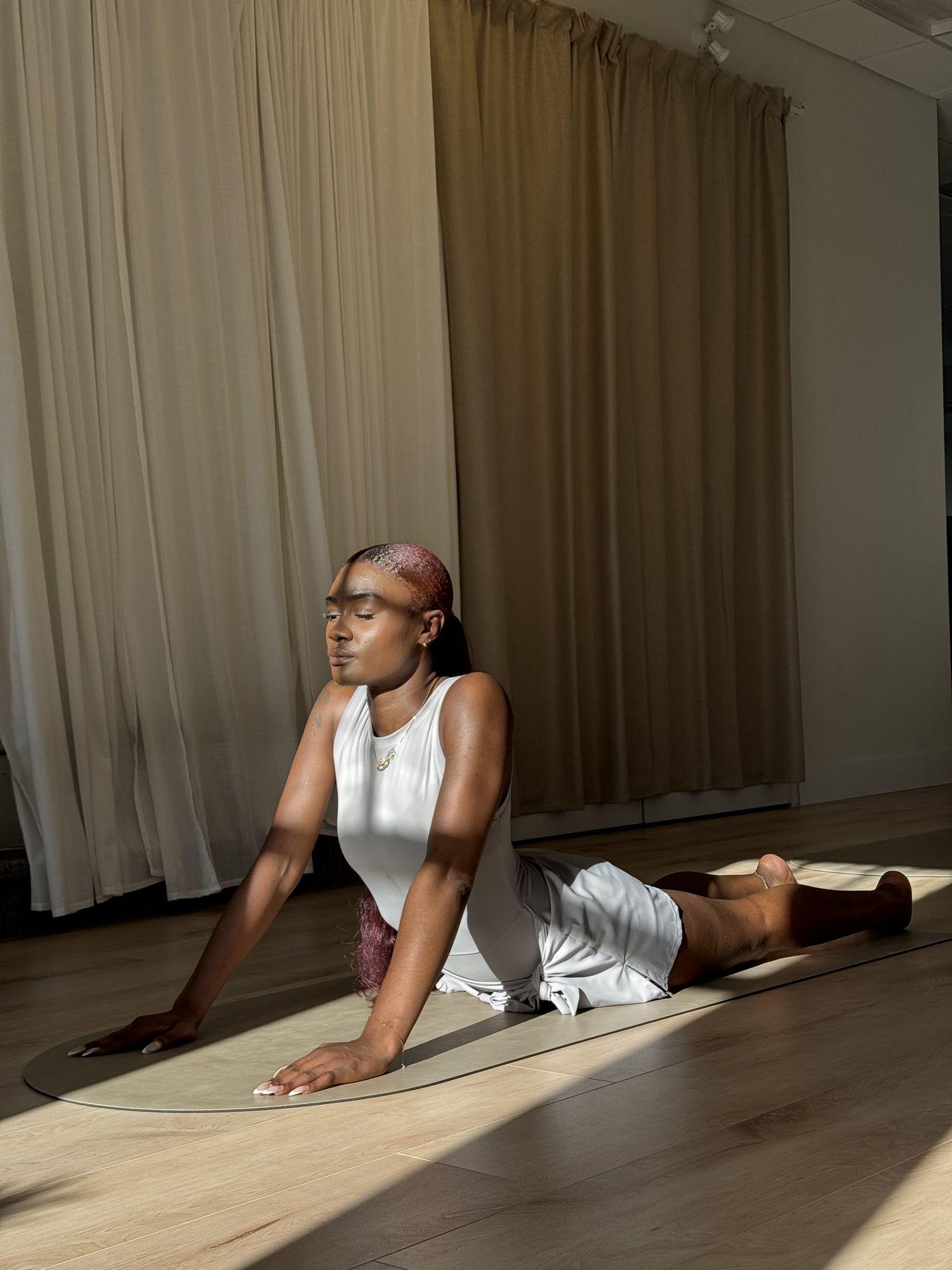 Woman stretching on a mat in a bright studio